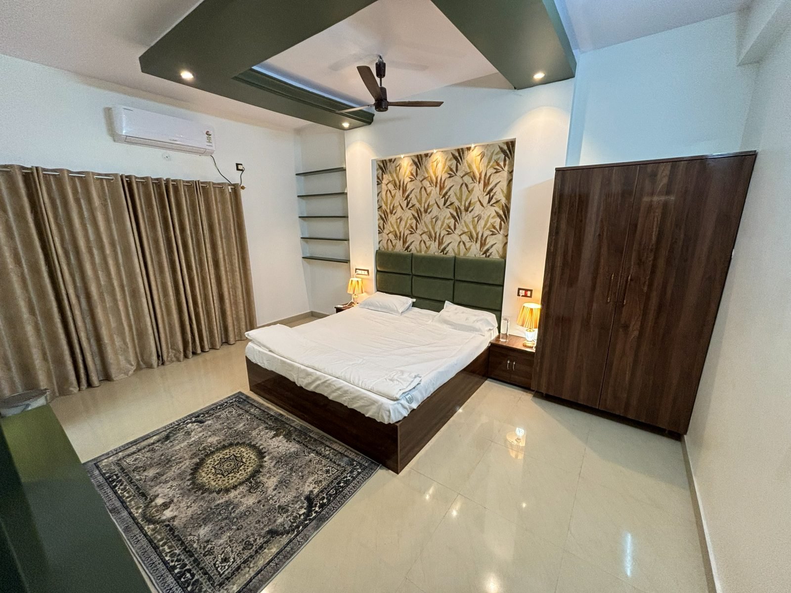 Deluxe bedroom with a patterned rug and leaf-motif feature wall