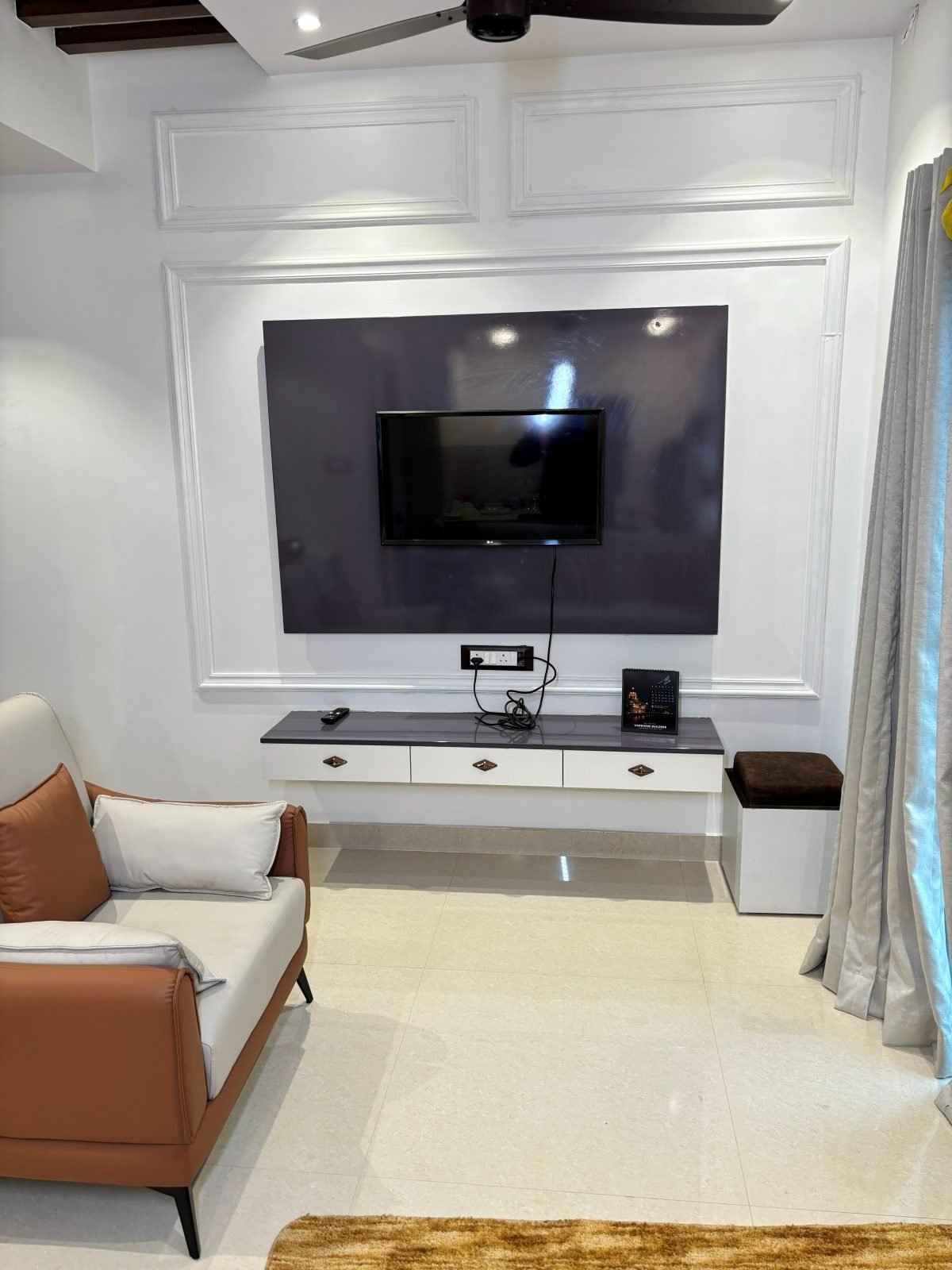 Living room media wall with a lounge chair